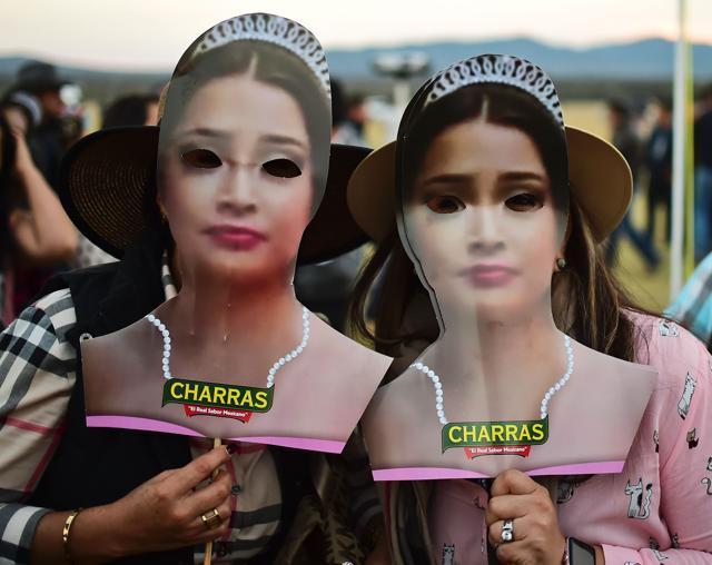 Two women use face cut-outs depicting Mexican teenager Rubi Ibarra during her 15th birthday party in Villa Guadalupe. (AFP)