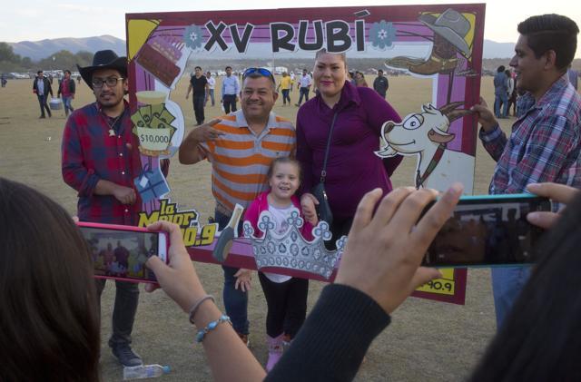 Visitors have their picture taken behind a frame honoring Rubi Ibarra during celebrations for her down-home 15th birthday near the village of Laguna Seca, San Luis Potosi State, Mexico. (AP Photo) Visitors have their picture taken behind a frame honoring Rubi Ibarra during celebrations for her down-home 15th birthday near the village of Laguna Seca, San Luis Potosi State, Mexico. (AP Photo)