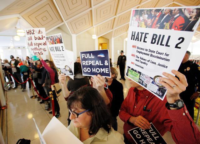 Opponents of North Carolina's HB2 law limiting bathroom access for transgender people protest in the gallery above the state's House of Representatives chamber as the legislature considers repealing the controversial law in Raleigh, North Carolina, US. (REUTERS) Opponents of North Carolina's HB2 law limiting bathroom access for transgender people protest in the gallery above the state's House of Representatives chamber as the legislature considers repealing the controversial law in Raleigh, North Carolina, US. (REUTERS)