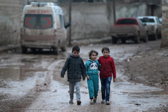 Children walk near a parked ambulance in al-Rai town, northern Aleppo province in Syria. (REUTERS)