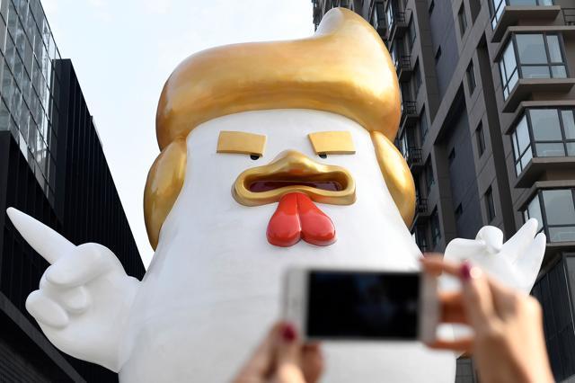 A woman using her smartphone to take a photo of the giant chicken sculpture. (AFP Photo) A woman using her smartphone to take a photo of the giant chicken sculpture. (AFP Photo)
