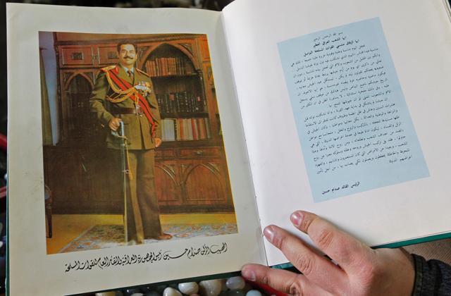 An Iraqi shopkeeper holds a book bearing a portrait of late Iraqi president Saddam Hussein at his shop in Baghdad. (AFP photo) An Iraqi shopkeeper holds a book bearing a portrait of late Iraqi president Saddam Hussein at his shop in Baghdad. (AFP photo)