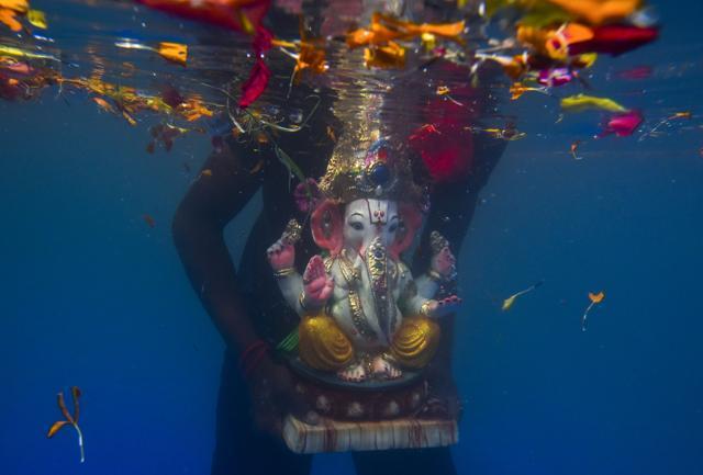 An idol of Lord Ganesha is immersed in an artificial pond in Mumbai. The city’s biggest festival has gone environment-friendly , with more and people using eco friendly idols and immersing them in artificial water bodies. (Kunal Patil/ HT PhotoH)