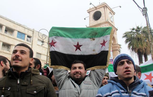Dozens of Syrians take part in a small gathering calling for the fall of the regime on December 30, 2016, in the northwestern city of Idlib. (AFP Photo)