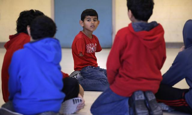 Syrian refugee Ahmad Alkhalaf kneels with friends after praying during a day camp for local Muslim children in Sharon, Massachusetts. (AP Photo) Syrian refugee Ahmad Alkhalaf kneels with friends after praying during a day camp for local Muslim children in Sharon, Massachusetts. (AP Photo)
