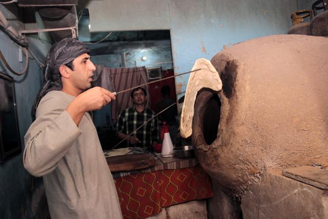 A migrant baking Afghan bread. (Shivam Saxena/ HT Photo)