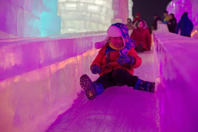 A boy takes a ride on an ice sculpture illuminated by coloured lights at the Harbin Ice and Snow Festival to celebrate the new year in Harbin on January 4, 2017. (AFP) A boy takes a ride on an ice sculpture illuminated by coloured lights at the Harbin Ice and Snow Festival to celebrate the new year in Harbin on January 4, 2017. (AFP)
