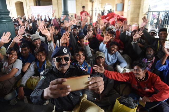 A Pakistani policeman takes a ‘selfie’ with Indian fishermen at the railway station in Karachi. (AFP Photo) A Pakistani policeman takes a ‘selfie’ with Indian fishermen at the railway station in Karachi. (AFP Photo)