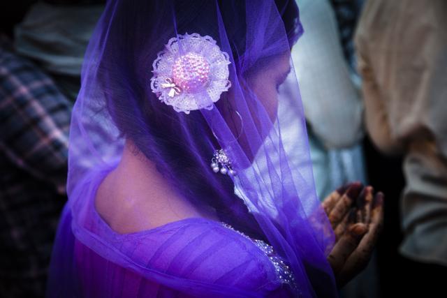 “I have always thought of colour as my language,” says Khanna. In this picture, taken at the Nizamuddin Dargah in Delhi, a devotee is seen praying, her henna-coloured palms raised upwards, her head bowed and covered with a deep purple net dupatta. (Dinesh Khanna)