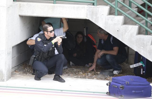 Law enforcement personnel shield civilians outside a garage area at Fort Lauderdale–Hollywood International Airport, on January 6, 2017, in Fort Lauderdale, Florida. (AP Photo) Law enforcement personnel shield civilians outside a garage area at Fort Lauderdale–Hollywood International Airport, on January 6, 2017, in Fort Lauderdale, Florida. (AP Photo)