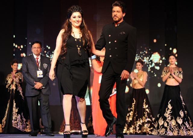 Indian Bollywood actor Shah Rukh Khan (L) takes part in a charity fashion show by designer Archana Kochhar (R) in Mumbai on January 8, 2017. (AFP)