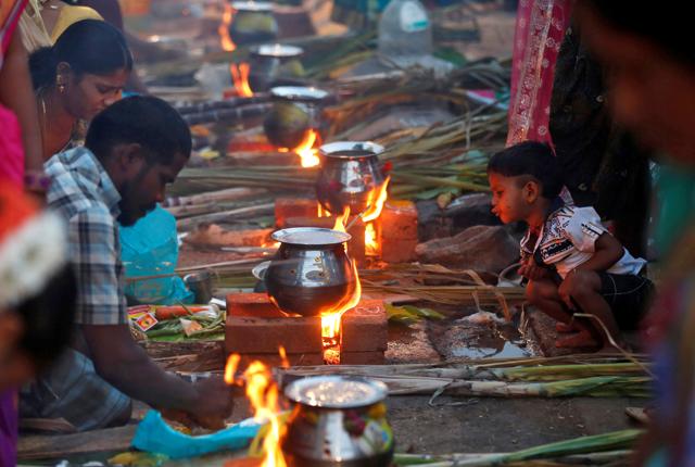 Tiny flames light up the road as devotees prepare rice dishes to offer to the Hindu Sun God in Dharavi, Mumbai. (Reuters Photo) Tiny flames light up the road as devotees prepare rice dishes to offer to the Hindu Sun God in Dharavi, Mumbai. (Reuters Photo)