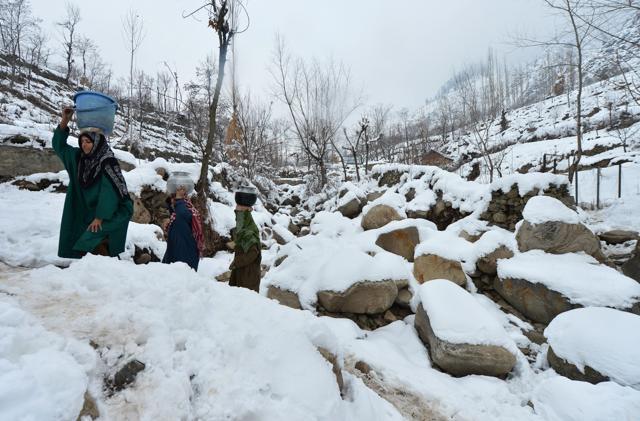 Kashmiri Muslim villagers carry drinking water pots along a snow-covered road on the outskirts of Srinagar on Friday. (AFP) Kashmiri Muslim villagers carry drinking water pots along a snow-covered road on the outskirts of Srinagar on Friday. (AFP)