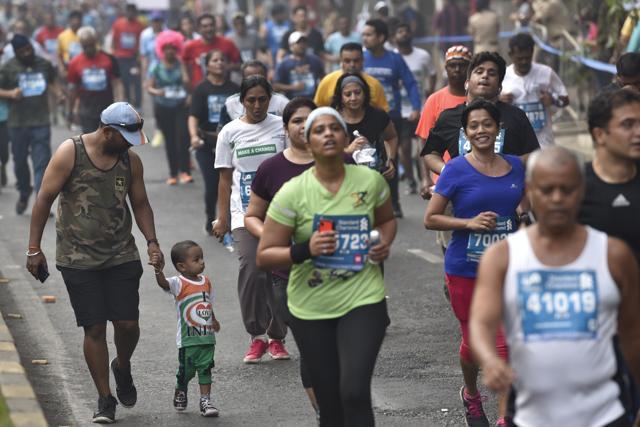 A man with his kid participates in the marathon on Sunday. (Arijit Sen/HT PHOTO)