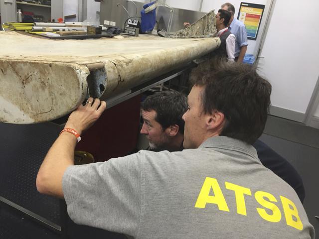 In this July 20, 2016 file photo released by the Australian Transport Safety Bureau (ATSB), investigators examine a piece of aircraft debris at their laboratory in Canberra, Australia. After nearly three years, the hunt for Malaysia Airlines Flight 370 ended in futility and frustration on Jan. 17, 2017, as crews completed their deep-sea search of a desolate stretch of the Indian Ocean without finding a single trace of the plane. (AP Photo)
