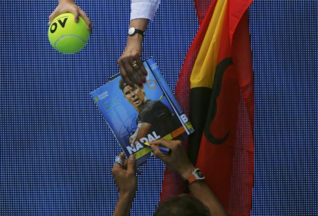 Rafael Nadal signs autographs after winning his Australian Open men's singles first round match against Germany's Florian Mayer on Tuesday (REUTERS) Rafael Nadal signs autographs after winning his Australian Open men's singles first round match against Germany's Florian Mayer on Tuesday (REUTERS)
