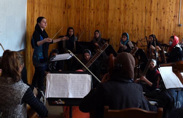 Nineteen year-old Afghan Negina Khpalwak (L), the first female orchestra conductor in Afghanistan, conducts her musicians during a rehearsal at The Afghanistan National Institute of Music in Kabul. (AFP Photo) Nineteen year-old Afghan Negina Khpalwak (L), the first female orchestra conductor in Afghanistan, conducts her musicians during a rehearsal at The Afghanistan National Institute of Music in Kabul. (AFP Photo)