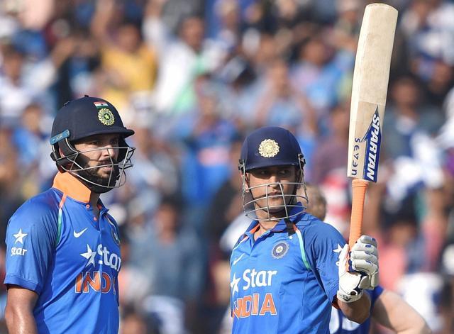 Mahendra Singh Dhoni acknowledges the crowd after reaching his century as Yuvraj Singh looks on. (PTI)