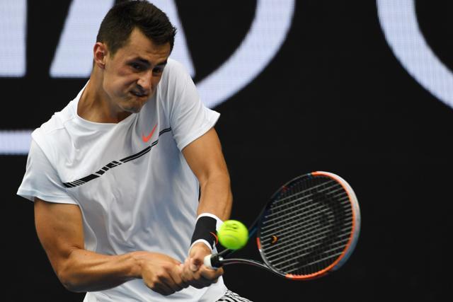 Australia's Bernard Tomic hits a return against Britain's Daniel Evans during their men's singles third round match on day five of the Australian Open. (AFP)