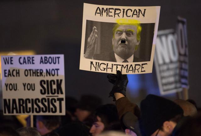 Protesters hold up signs at the rally. (AFP)