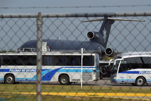 Buses block the view of Cuban citizens boarding a Federal Police airplane bound to La Havana, Cuba, after being deported from Mexico, at the international airport in Tapachula, Mexico on January 20, 2017. (REUTERS)