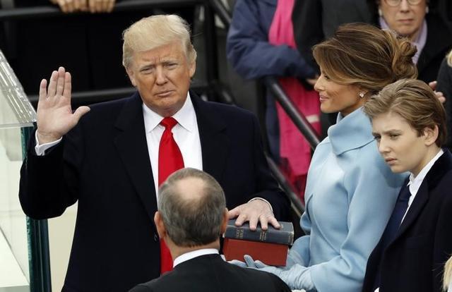 US President Donald Trump takes the oath of office with his wife Melania and son Barron at his side, during his inauguration at the US Capitol in Washington. (Reuters Photo)