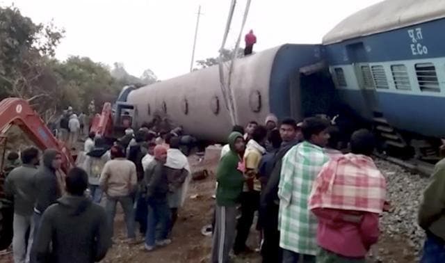 In this image from video, rescuers and onlookers stand around coaches of a derailed passenger train in Kuneru, Andhra Pradesh. (AP)