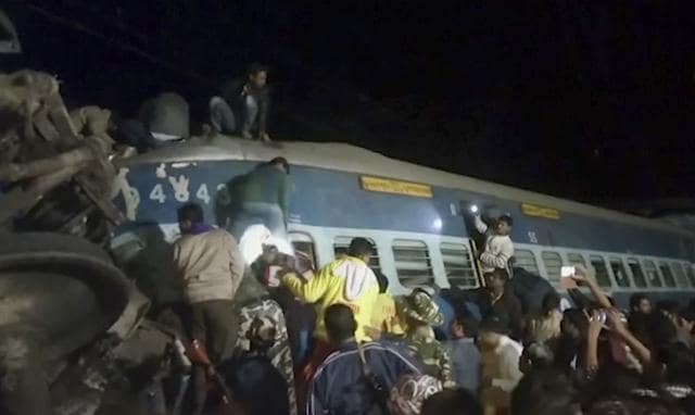 In this image from video, rescuers climb a coach of a derailed passenger train in Kuneru, Andhra Pradesh. (AP)
