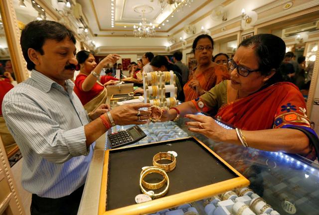 A salesman shows gold bangles to a customer at a jewellery showroom during Dhanteras, a Hindu festival associated with Lakshmi, the goddess of wealth, in Kolkata. (Reuters) A salesman shows gold bangles to a customer at a jewellery showroom during Dhanteras, a Hindu festival associated with Lakshmi, the goddess of wealth, in Kolkata. (Reuters)