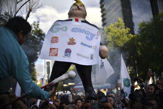 A pinata (dummy) representing US President Donald Trump is broken during a protest against his inauguration in front of the US embassy compound in Mexico City. (AFP Photo) A pinata (dummy) representing US President Donald Trump is broken during a protest against his inauguration in front of the US embassy compound in Mexico City. (AFP Photo)