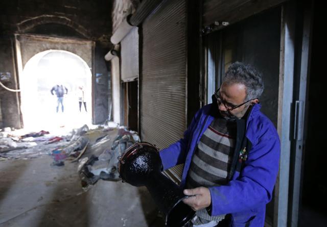 Mohammed Nour Mimi looks at a drum as he rummages through his store to find surviving musical instruments in Aleppo's historic souk. (AFP) Mohammed Nour Mimi looks at a drum as he rummages through his store to find surviving musical instruments in Aleppo's historic souk. (AFP)