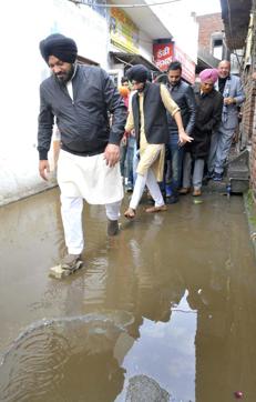 Gurpreet Waraich passing through a road overflowing with rainwater while campaigning in Batala on Wednesday. (Keshav Singh/HT Photo) Gurpreet Waraich passing through a road overflowing with rainwater while campaigning in Batala on Wednesday. (Keshav Singh/HT Photo)