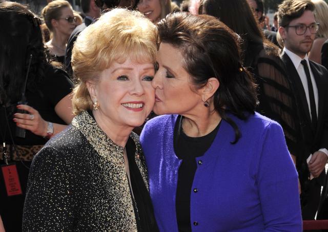 In this 2011 file photo, Carrie Fisher kisses her mother, Debbie Reynolds, as they arrive at the Primetime Creative Arts Emmy Awards in Los Angeles. (AP)