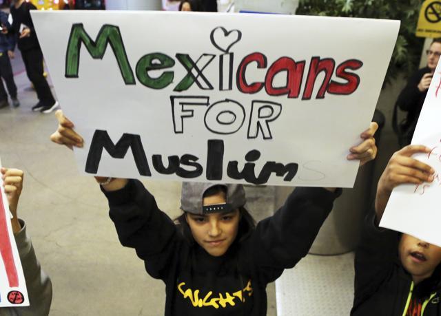 A young girl joins hundreds of people opposed to President Donald Trump's executive order barring entry to the U.S. by Muslims from certain countries as they demonstrate at the Tom Bradley International Terminal at Los Angeles International Airport Saturday, Jan. 28, 2017. (AP Photo) A young girl joins hundreds of people opposed to President Donald Trump's executive order barring entry to the U.S. by Muslims from certain countries as they demonstrate at the Tom Bradley International Terminal at Los Angeles International Airport Saturday, Jan. 28, 2017. (AP Photo)