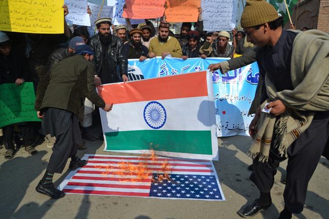 Hafiz Saeed supporters burn US and Indian flags to condemn his house arrest. (AP) Hafiz Saeed supporters burn US and Indian flags to condemn his house arrest. (AP)