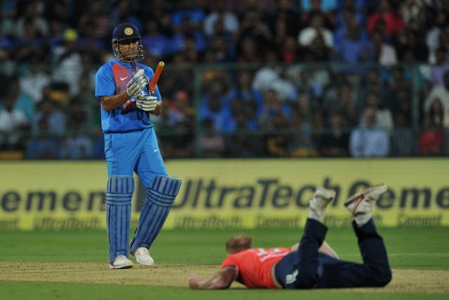 MS Dhoni looks on as England bowler Ben Stokes dives to stop the ball during the third T20 between India and England at the Chinnaswamy Stadium in Bangalore on Wednesday. (AFP)