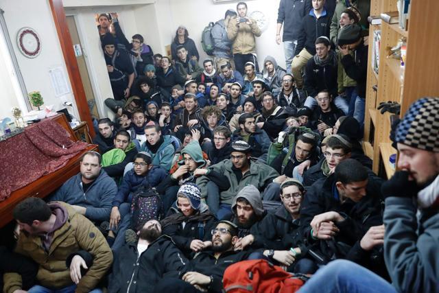Israeli settlers sit in protest at the Amona outpost, as security forces evict hardline occupants of settlement outpost on Wednesday. (AFP) Israeli settlers sit in protest at the Amona outpost, as security forces evict hardline occupants of settlement outpost on Wednesday. (AFP)