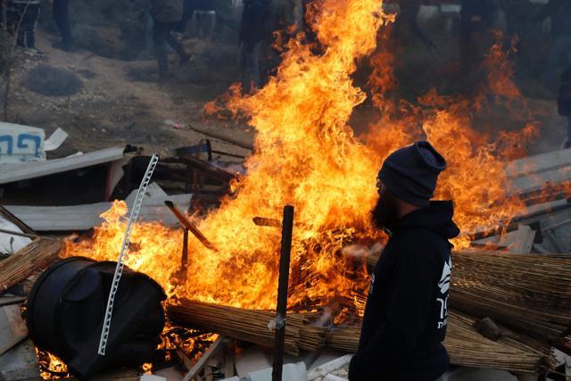 An Israeli settler stands next to burning furniture, as security forces evict hardline occupants of the wildcat settlement at Amona. (AFP) An Israeli settler stands next to burning furniture, as security forces evict hardline occupants of the wildcat settlement at Amona. (AFP)