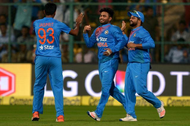 Rishabh Pant (centre) is greeted by teammate Suresh Raina (right) after the catching out England batsman Eoin Morgan during the third T20 at Chinnaswamy Stadium in Bangalore on Wednesday. (AFP)