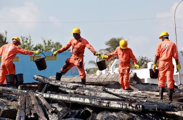 Emergency workers clean oil from the shoreline of Ennore port. (REUTERS) Emergency workers clean oil from the shoreline of Ennore port. (REUTERS)