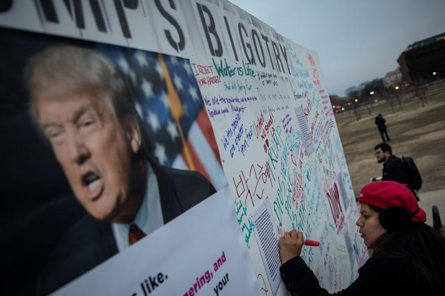 Protesters write 'messages of resistance' to President Donald Trump and his executive orders on a wall near the Washington Monument. The protest is aimed at President Trump's travel ban policy. (AFP) Protesters write 'messages of resistance' to President Donald Trump and his executive orders on a wall near the Washington Monument. The protest is aimed at President Trump's travel ban policy. (AFP)