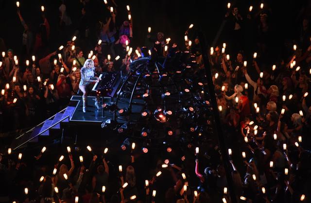 Lady Gaga performs as audience members swing lights to her music. (USA Today Sports)