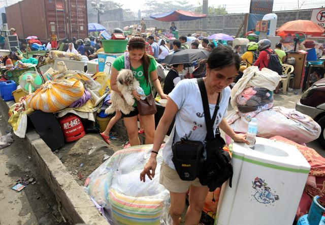 Fire victims gathers along a street after a fire destroyed more than hundreds of shanties. (Reuters Photo) Fire victims gathers along a street after a fire destroyed more than hundreds of shanties. (Reuters Photo)