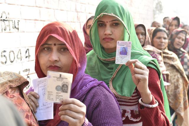 Women show thier ID cards outside polling station in Majitha constituency. (Gurpreet Singh/HT photo)