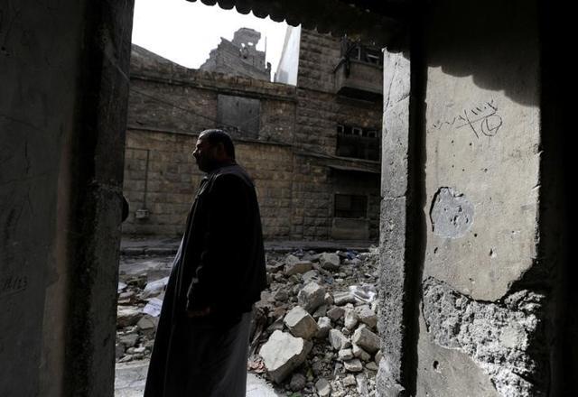 Eymad, 54, stands at the entrance of his family's building at al-Mouassassi street in Aleppo, Syria January 30. (Reuters) Eymad, 54, stands at the entrance of his family's building at al-Mouassassi street in Aleppo, Syria January 30. (Reuters)