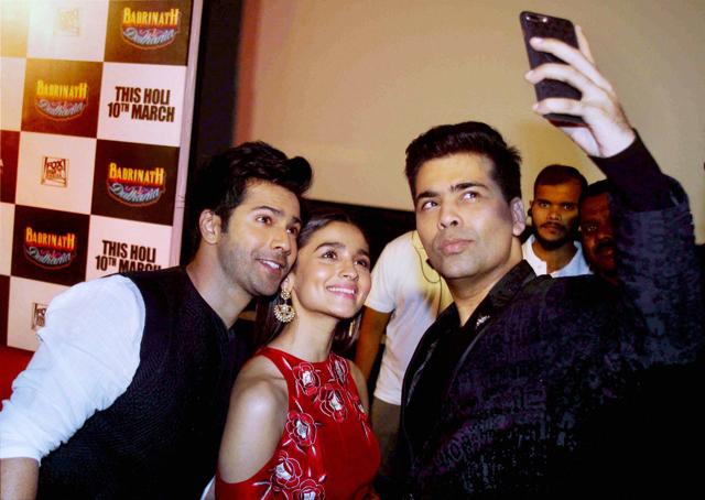 Varun Dhawan and Alia Bhatt with filmmaker Karan Johar during the trailer launch of their film Badrinath Ki Dulhaniya in Mumbai on Thursday. (PTI)