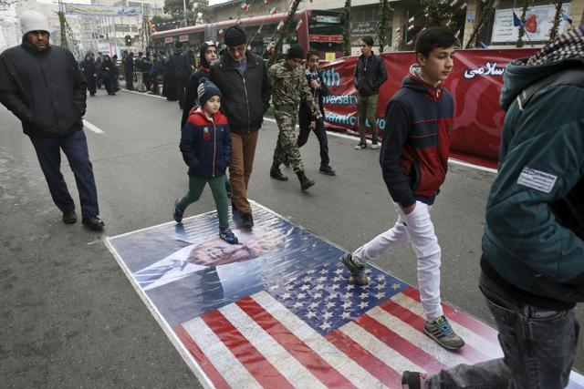 Iranians march on a portrait of US President Donald Trump and a picture of the US flag in an annual rally commemorating the 1979 Islamic revolution. (AP) Iranians march on a portrait of US President Donald Trump and a picture of the US flag in an annual rally commemorating the 1979 Islamic revolution. (AP)