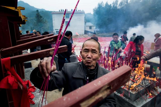 This picture taken on February 10 shows villagers praying and burning incense during the "beat the Buddha" celebration in Yuxi village. (AFP) This picture taken on February 10 shows villagers praying and burning incense during the "beat the Buddha" celebration in Yuxi village. (AFP)
