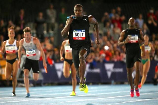 Usain Bolt runs after receiving the baton from teammate and compatriot Asafa Powell during the final night of the Nitro Athletics series at the Lakeside Stadium in Melbourne, Australia on Saturday. (Reuters) Usain Bolt runs after receiving the baton from teammate and compatriot Asafa Powell during the final night of the Nitro Athletics series at the Lakeside Stadium in Melbourne, Australia on Saturday. (Reuters)