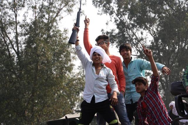 Youths brandishing a gun at Jassia in Rohtak district on Sunday. (Manoj Dhaka/HT photo)